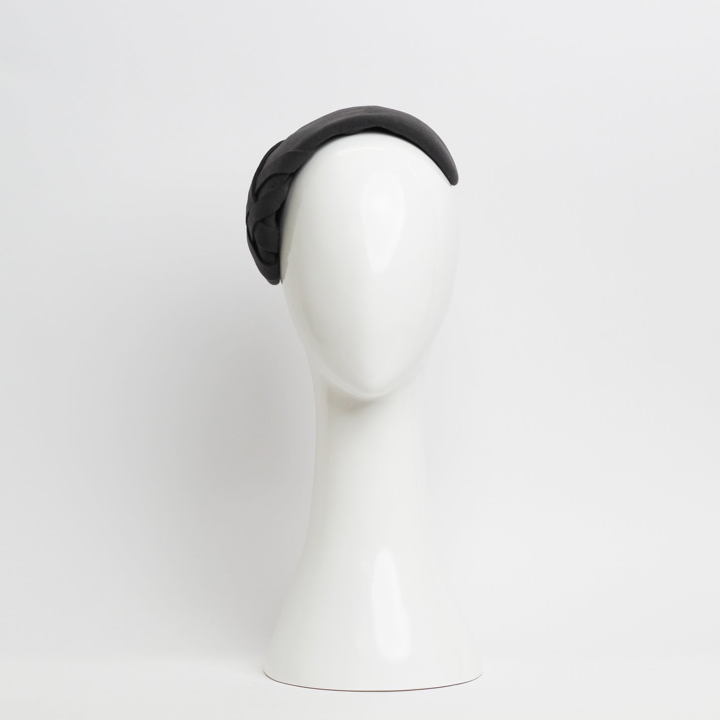 Grey felt headpiece that sits flush to the head with a small weave trim on the right hand side