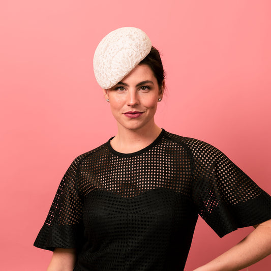 Model wears a black texture dress and white lace beret