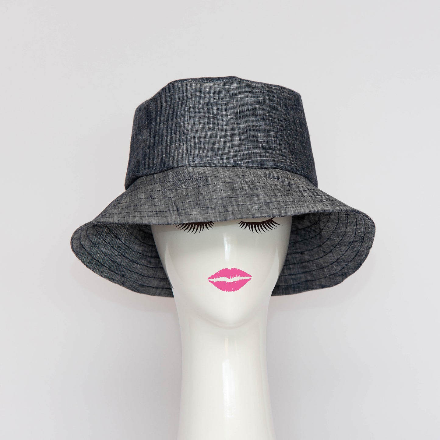 The Appin Bucket Hat in denim has a square shape crown with tip and side band. The flared brim is 8cm wide to protect you from the sun. Created by Melbourne based Lauren J Ritchie Millinery.