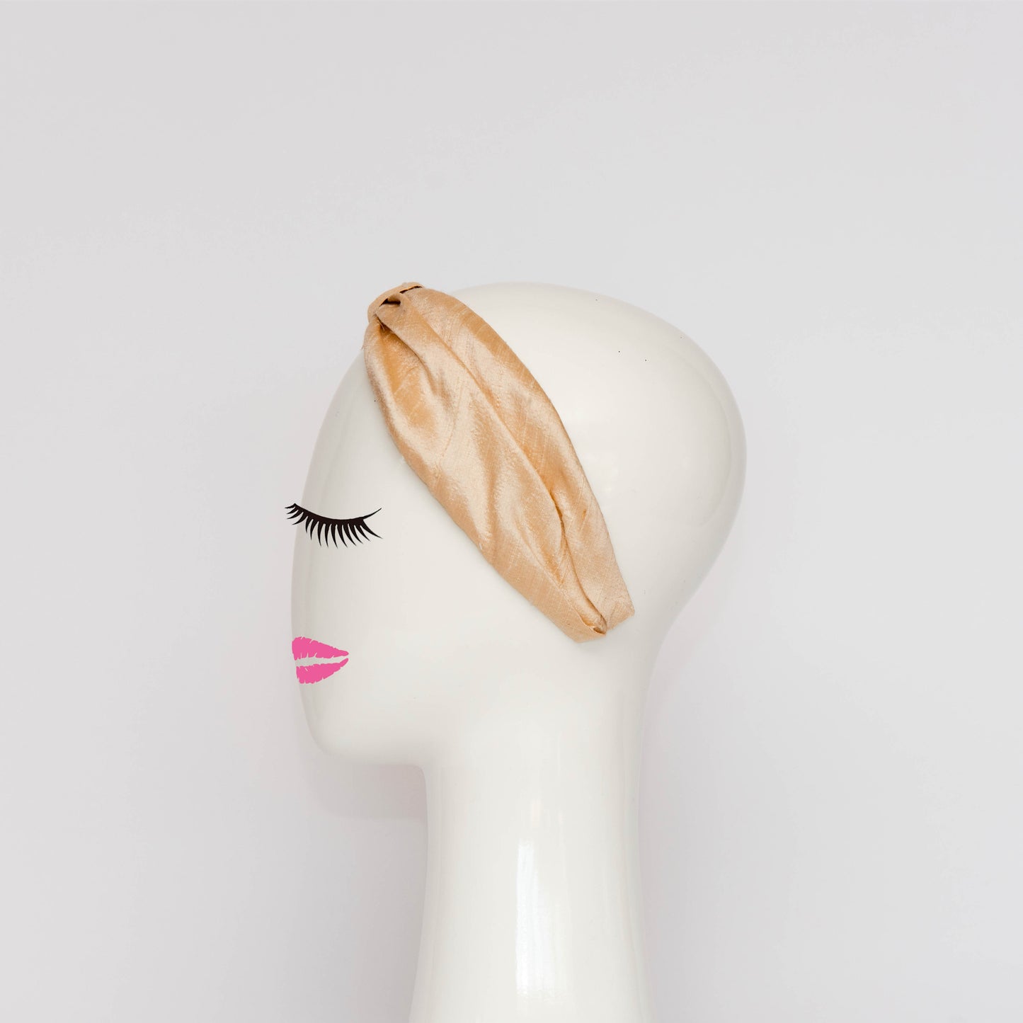 A side view of the Georgie Headband in black. The headband is a hand draped shape that is cinched with a centre wrap. The headpiece is created by Melbourne based Lauren J Ritchie Millinery.