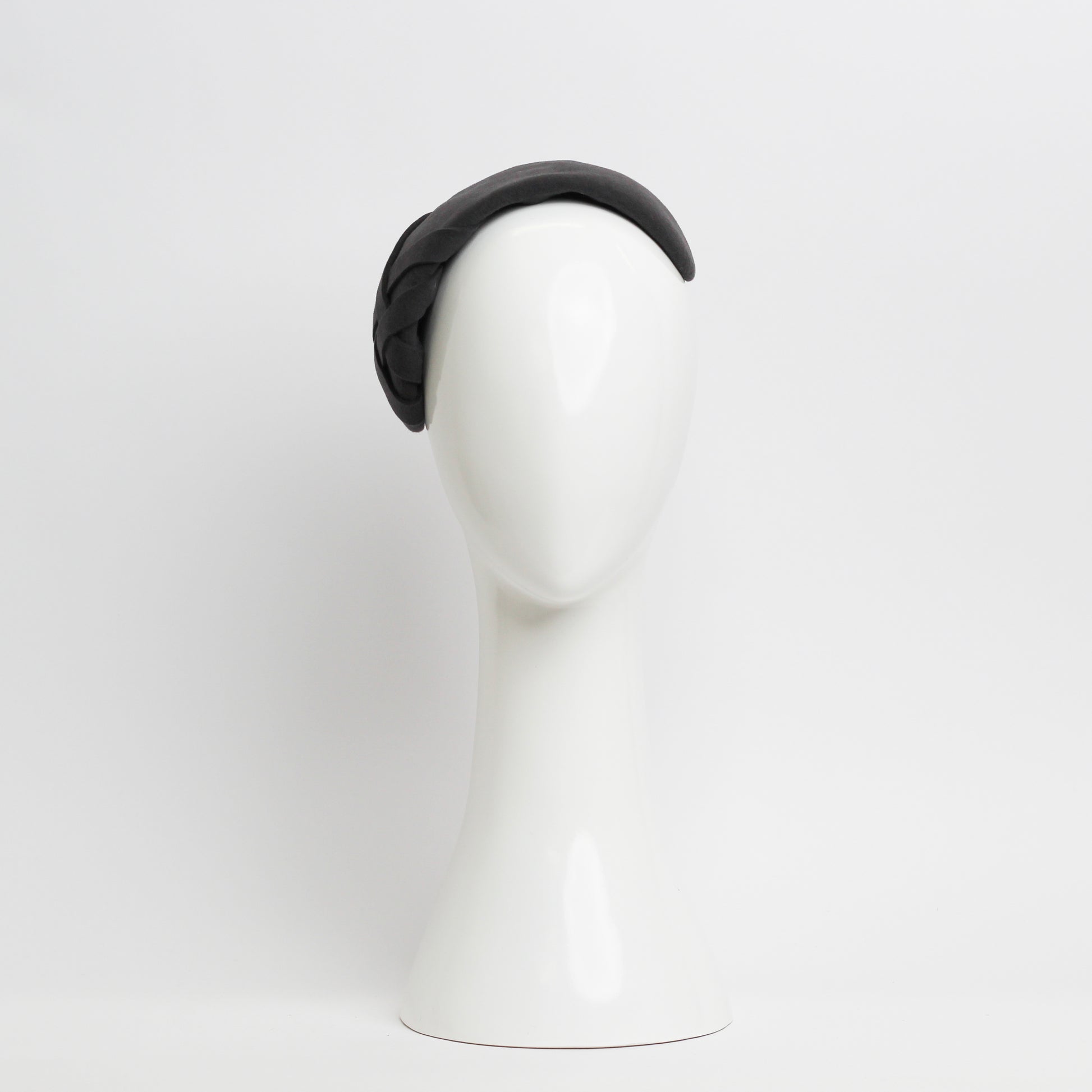 Grey felt headpiece that sits flush to the head with a small weave trim on the right hand side 