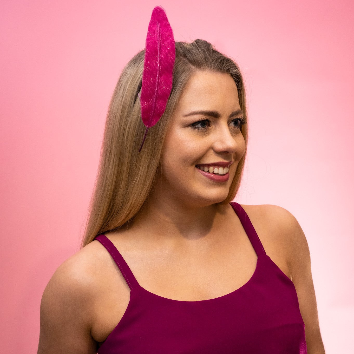 Side view of the Alba Headband in magenta, a floating tulle feather to the right hand side of the head. Created by Melbourne based Lauren J Ritchie Millinery.
