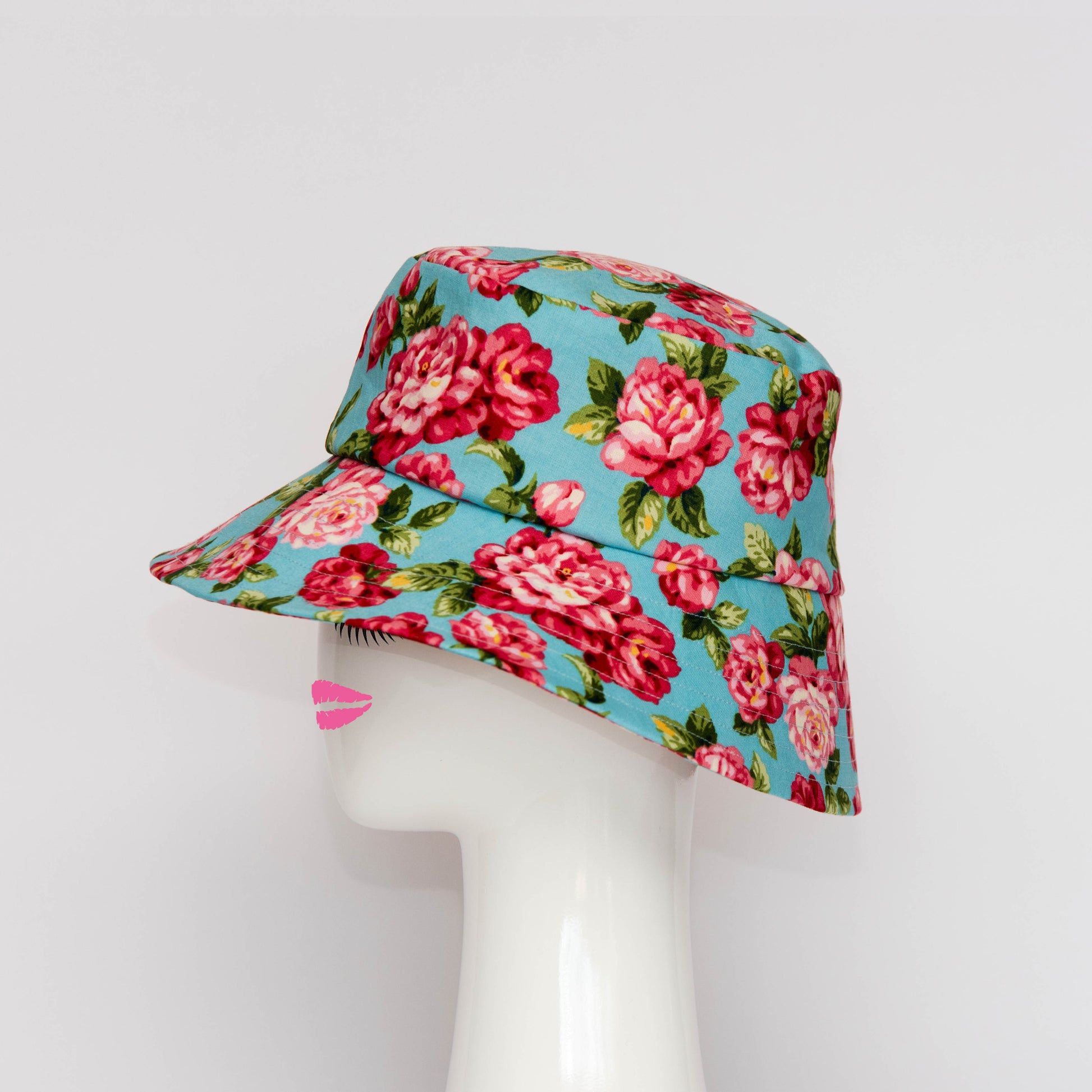 A side view of the Appin Bucket Hat in floral has a square shape crown with tip and side band.  Created by Melbourne based Lauren J Ritchie Millinery.